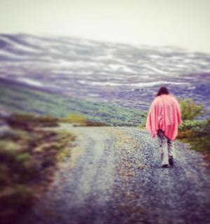 a person is walking down a dirt road