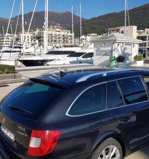 modré auto zaparkované na parkovišti s loděmi