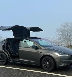 a smart car with its door open on a road