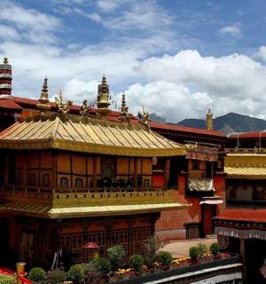 budova se zlatou střechou a horami v pozadí