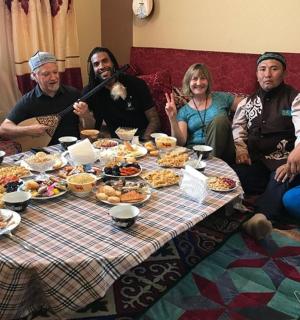 a group of people sitting around a table with food