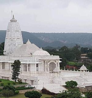 velká bílá budova s věží v poli