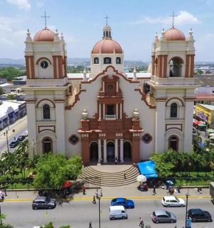 a church in a city with cars parked in a parking lot