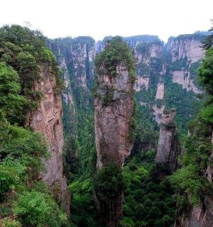 a view of a canyon with tall cliffs and trees