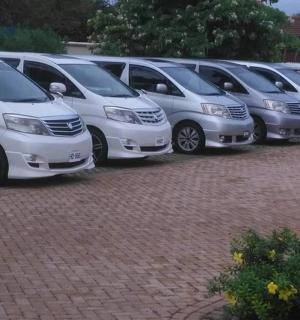 a row of white vans parked in a parking lot