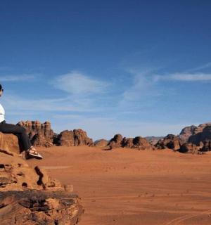 žena sedící na skále v poušti