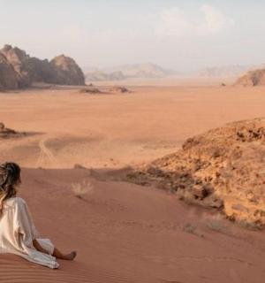 žena sedící na písku v poušti