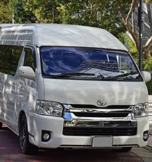 bir sokağın kenarına park edilmiş beyaz bir minibüs
