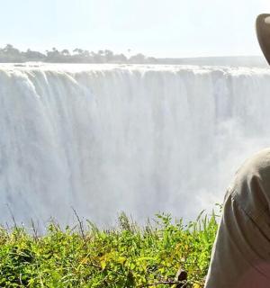 一名男子站在瀑布前