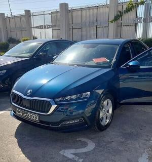 dvě modrá auta zaparkovaná na parkovišti