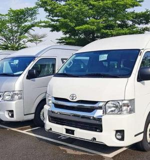 a row of white vans parked in a parking lot