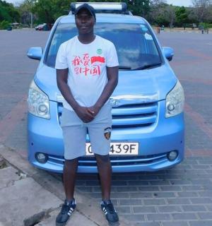 一名男子站在一辆蓝色货车前