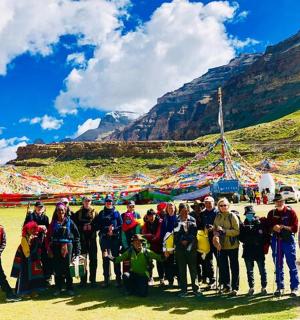 skupina lidí pózujících pro fotografii před horou