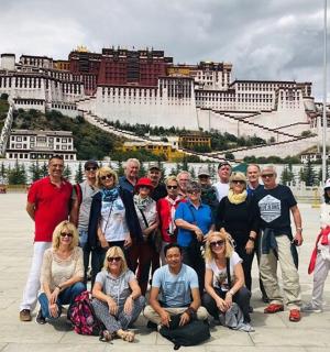 skupina lidí pózujících pro fotografii před městem