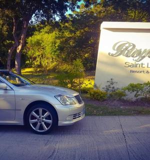 a silver car parked in front of a sign
