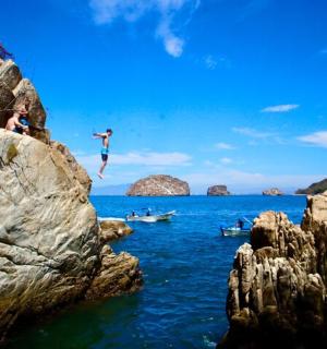 a person jumping off a rock into the water
