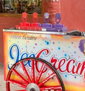 一辆冰淇淋车，上面放着一个蛋筒冰淇淋