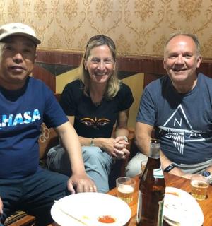 skupina tří lidí sedících u stolu