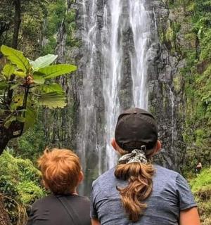 two people standing in front of a waterfall
