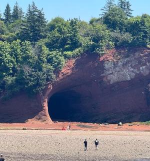 两个人站在一块巨大的岩石前