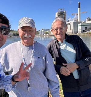 三个男人站在河边