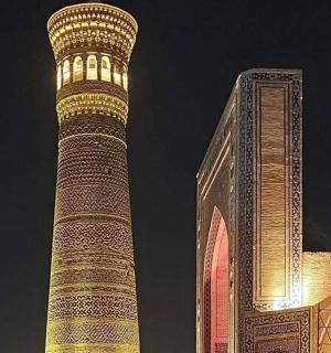 a tall tower next to a building with a clock tower