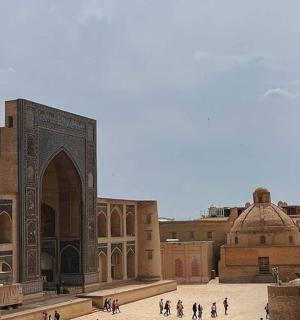 a group of people walking around a mosque