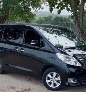 černá dodávka zaparkovaná v hlíně vedle stromu