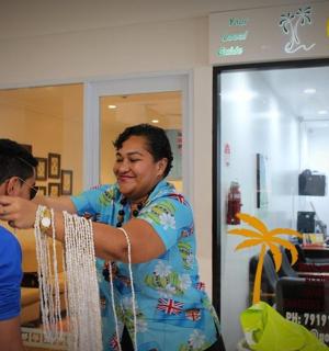 一名女子在商店里给一名男子剪头发