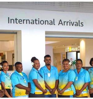 一群身穿蓝色衬衫的男子站在机场前