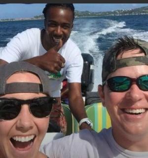 两名男子和一名女子在水中的船上