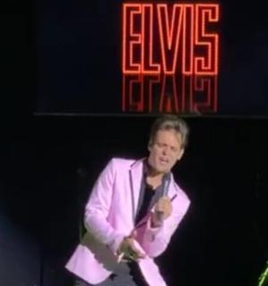 muž stojící na pódiu s kytarou