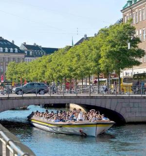 a group of people in a boat on the water under a bridge