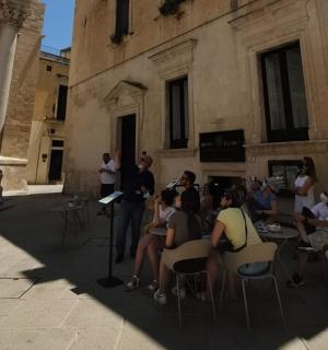 un gruppo di persone sedute su sedie davanti a un edificio