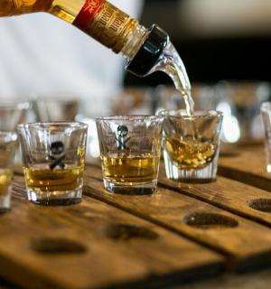 a bottle of whiskey being poured into glasses on a table