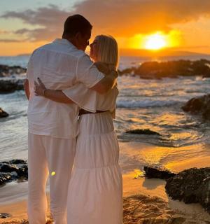 日落时分，一男一女站在海滩上