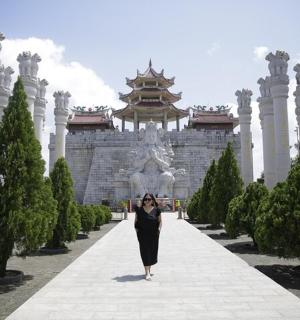 一位身穿黑色连衣裙的女子走在一栋建筑物前