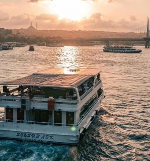 a ferry boat on the water with a bridge in the background