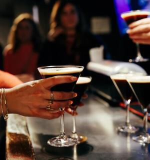 skupina lidí držících sklenice na víno v baru