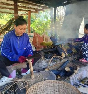 two women are cooking over an open fire