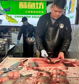 a man chopping up meat on top of a grill