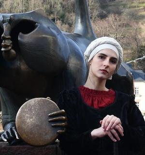 una donna è in piedi davanti a una statua