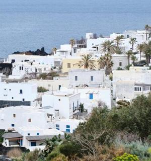 eine Ansammlung weißer Häuser auf einem Hügel mit Blick auf das Meer