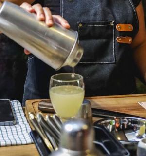 eine Person, die ein Getränk in ein Glas gießt