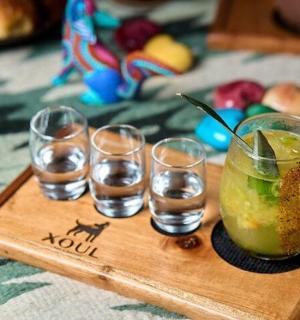 带有四个玻璃杯和一杯饮料的木托盘