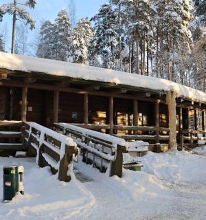 a wooden cabin with snow on it in the woods