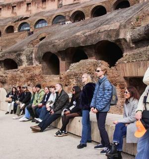 skupina lidí stojících před amfiteátrem