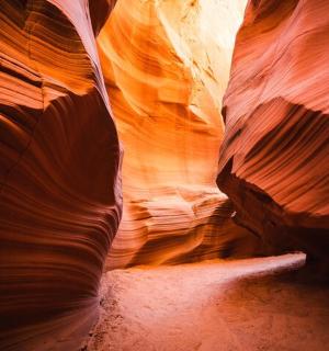 a slot canyon with a person walking through it