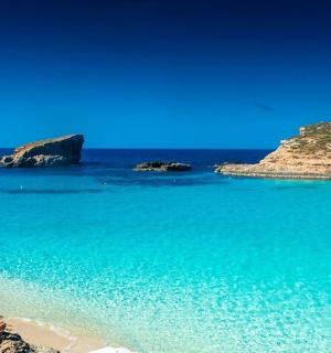 a group of people sitting on a beach near the water