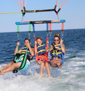 skupina tří lidí na houpačce ve vodě